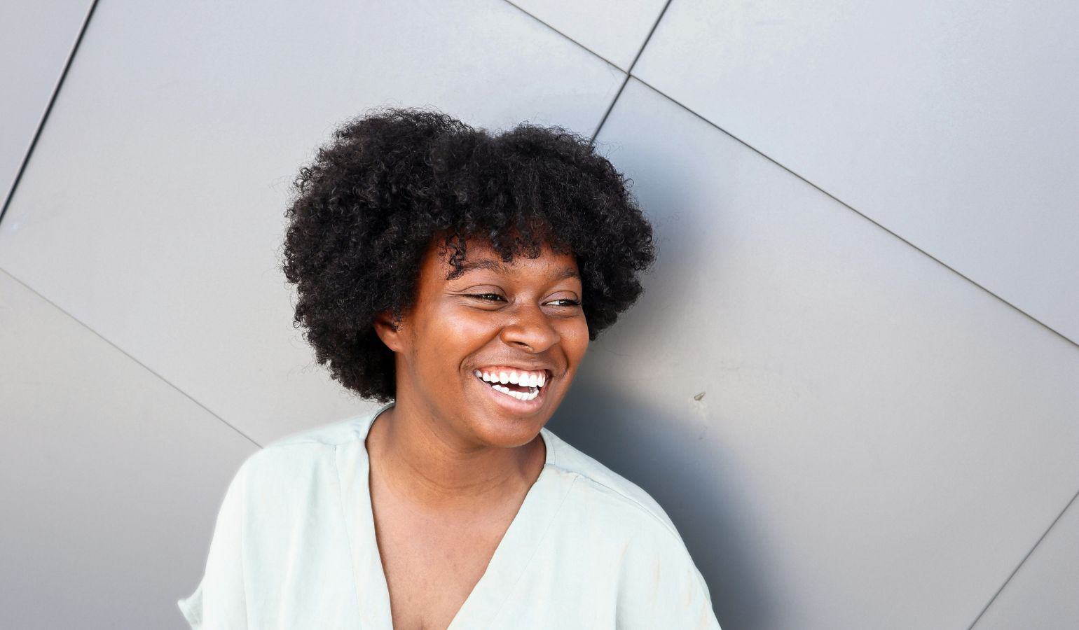 Black young woman laughing looking off to the side