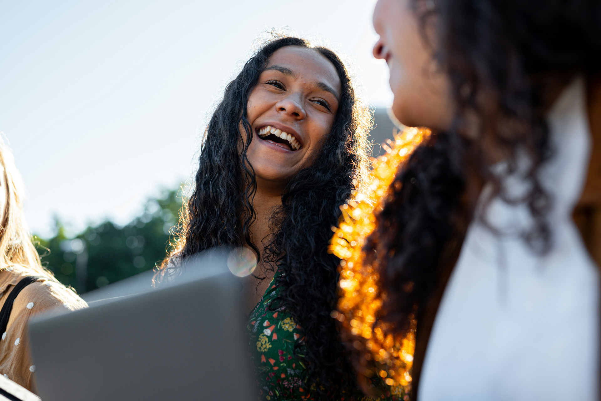 Young woman of hispanic heritage laughing with friends