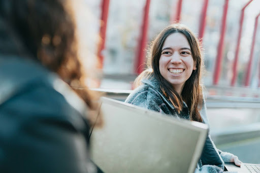 Young woman looking toward a friend and smiling.