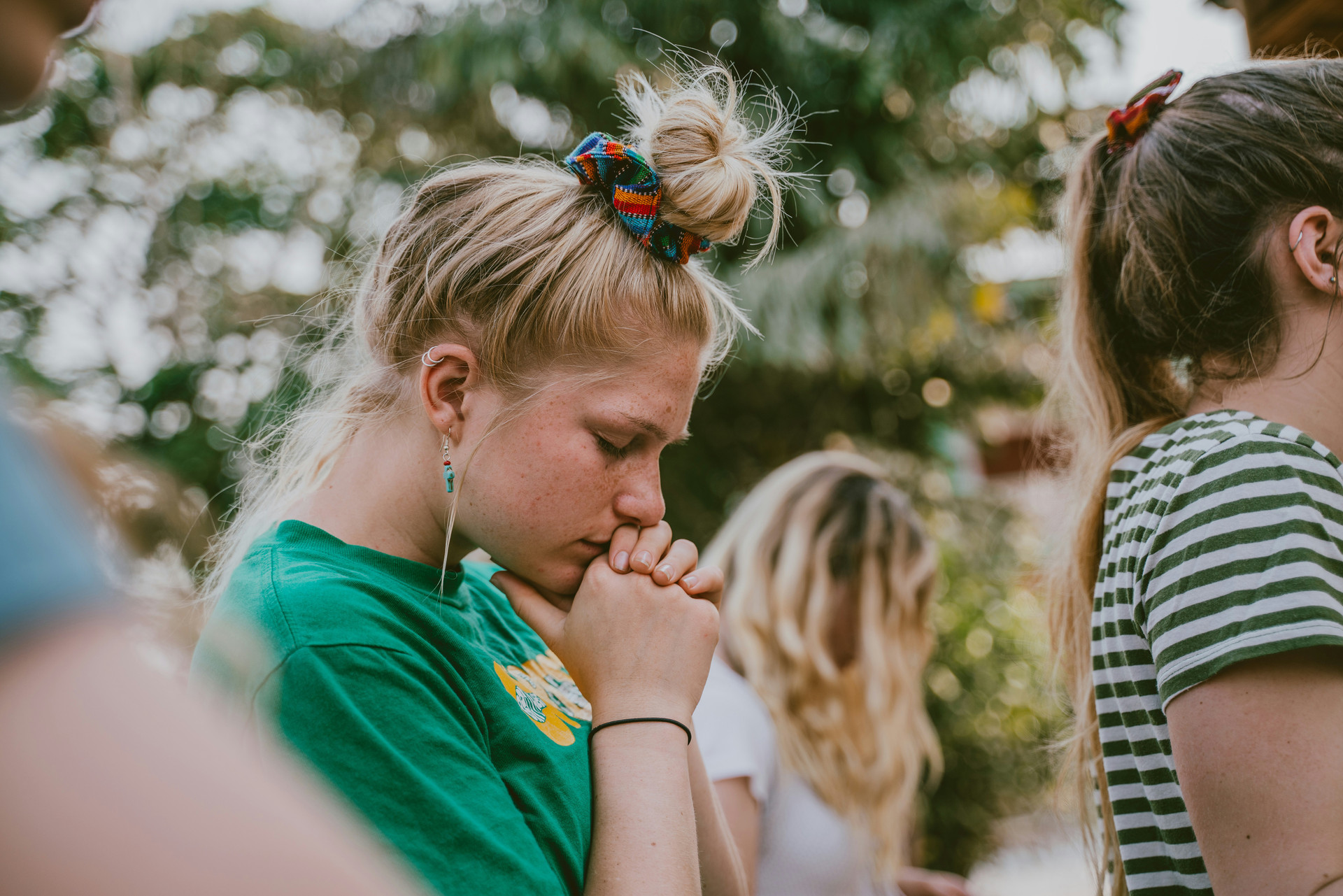 Young women standing together praying