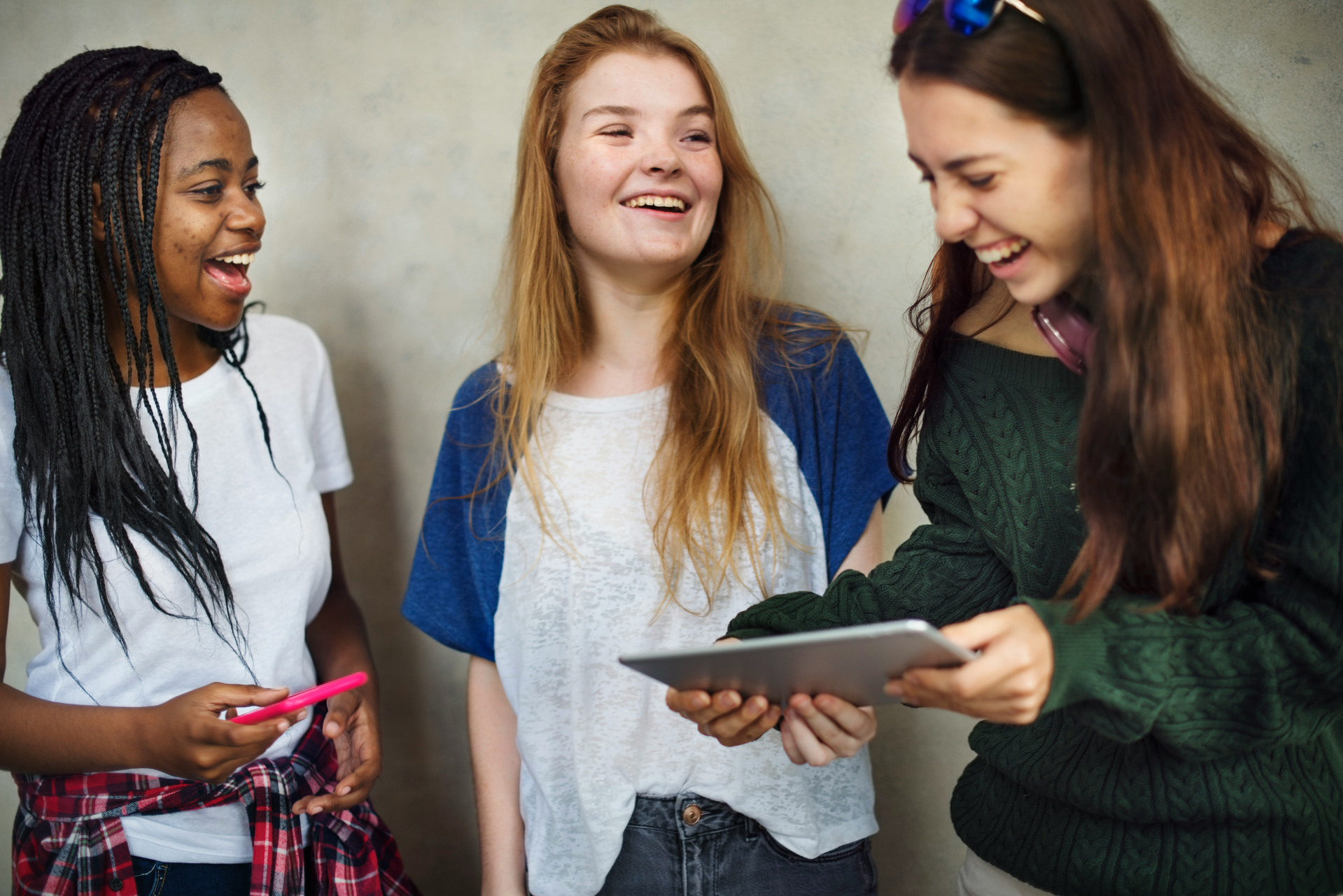 three teenage gals standing together laughing