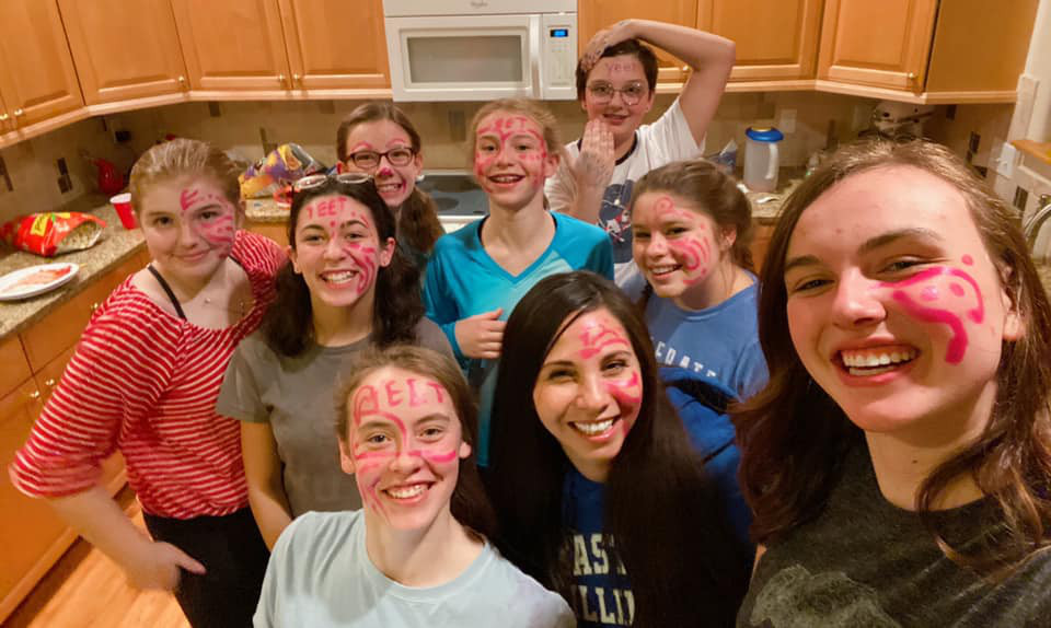 Yvette and teen girls with face paint at a youth event