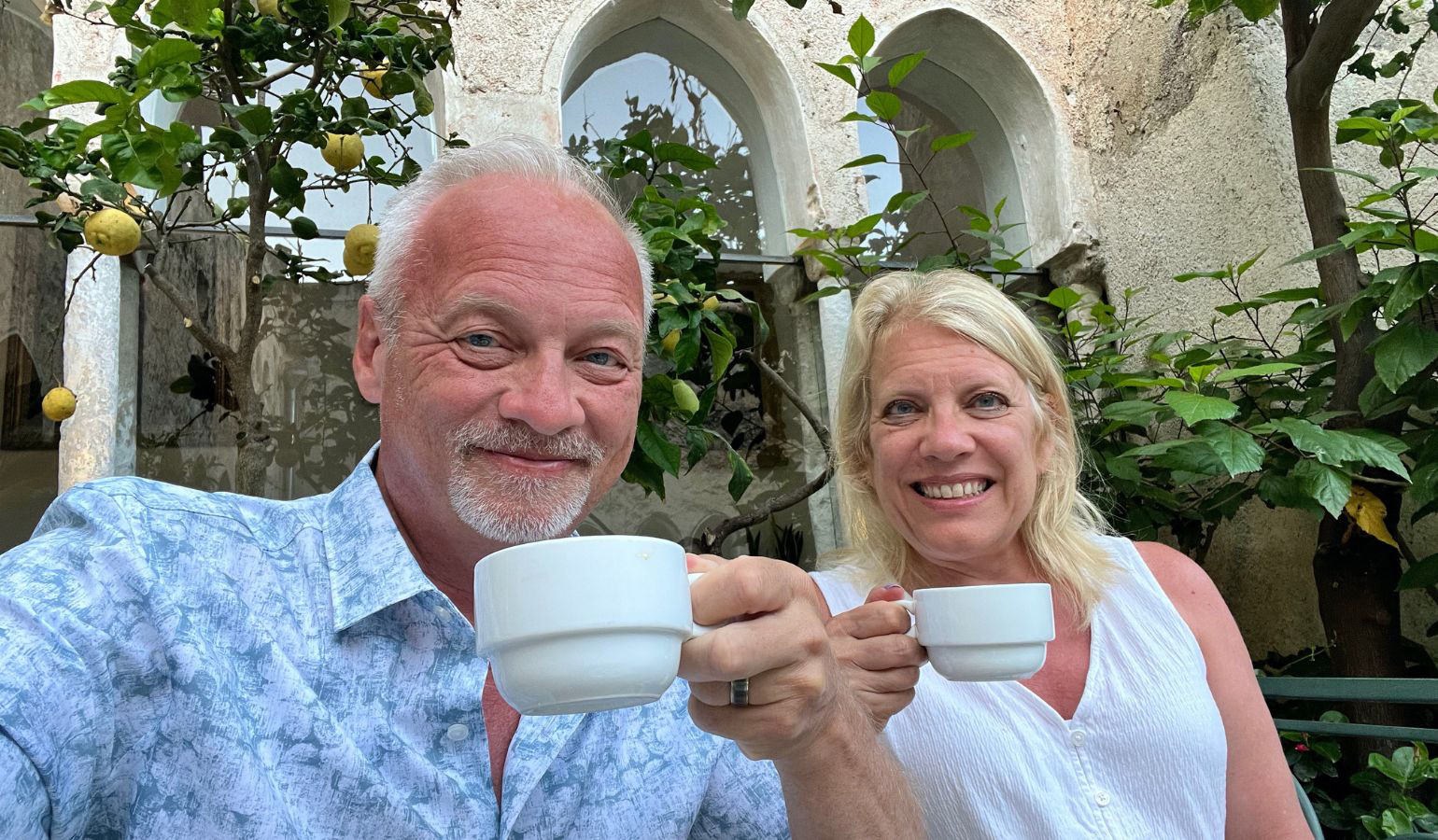 Janet & Rich holding up their coffee mugs smiling