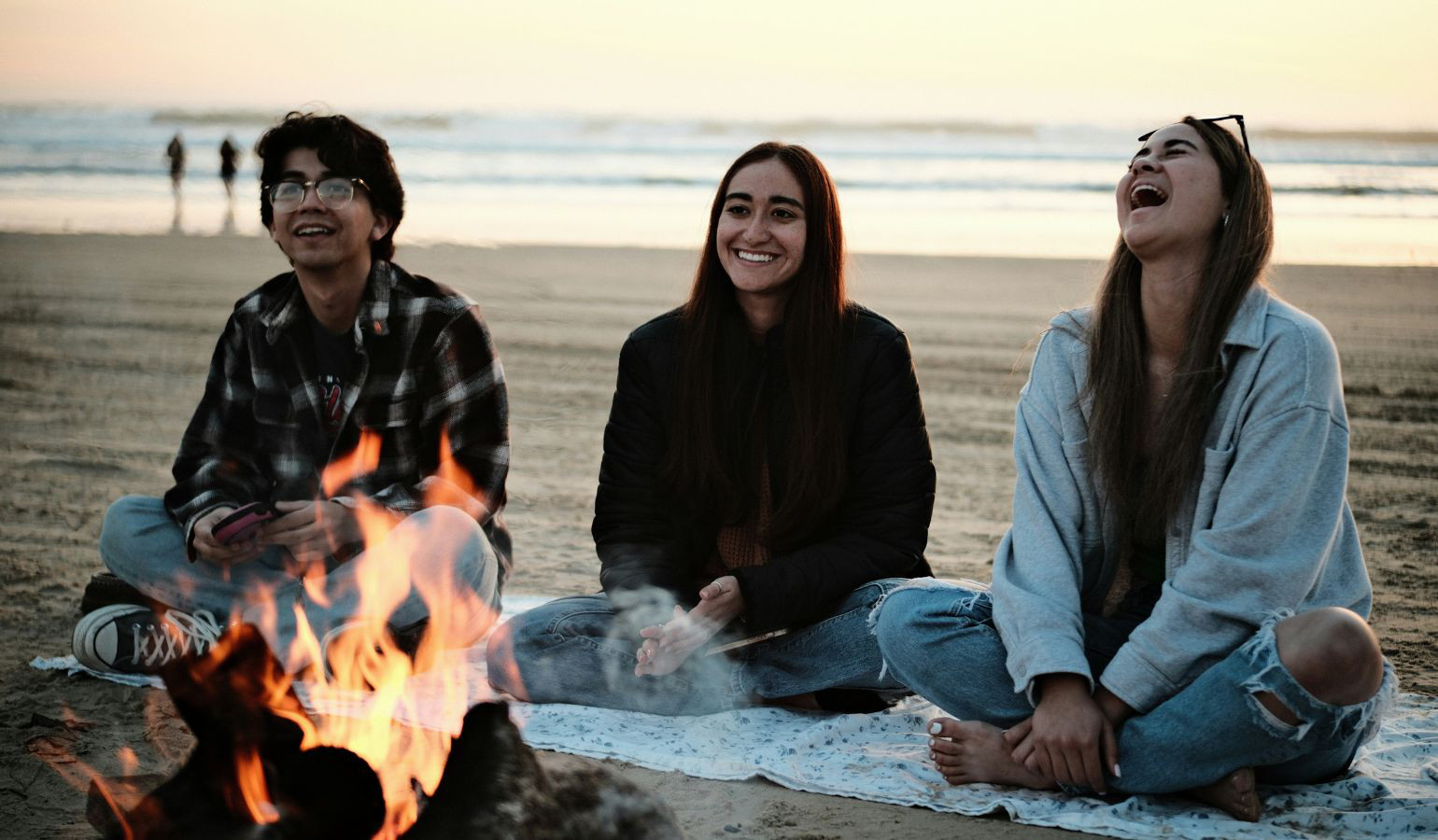 Students at a campfire at the beach.