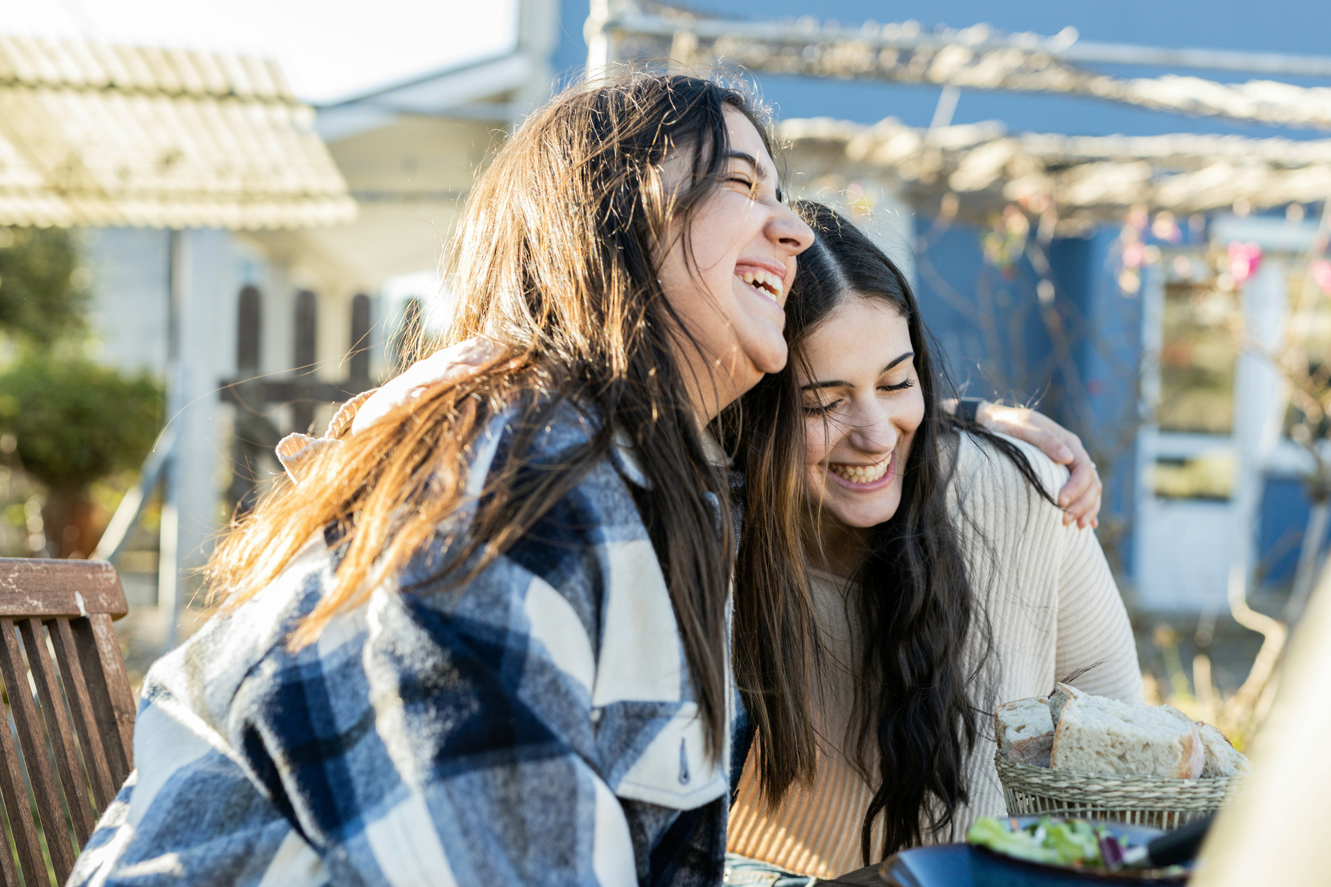 Young women side hugging and laughing