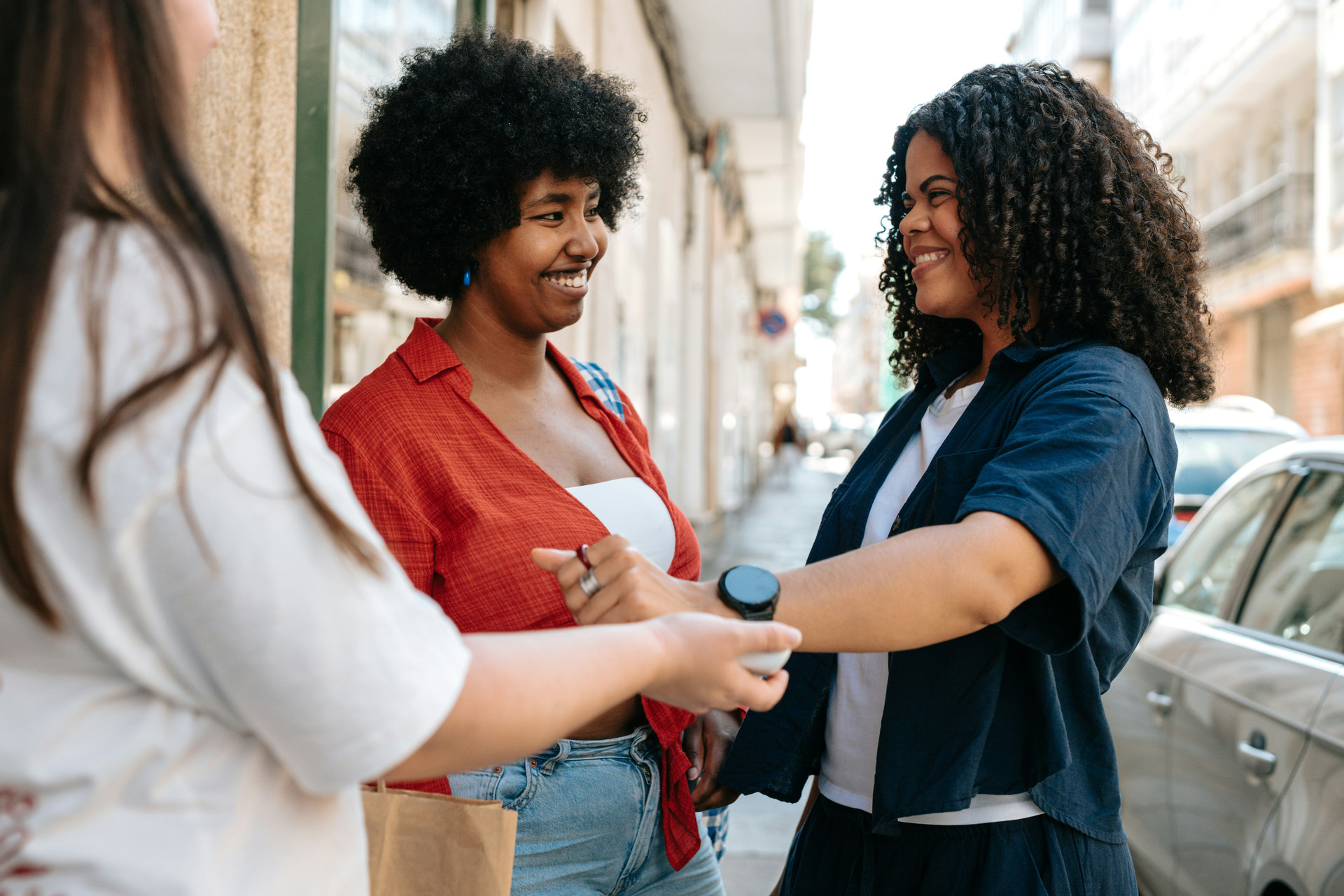Young women on a sidewalk talking and laughing.