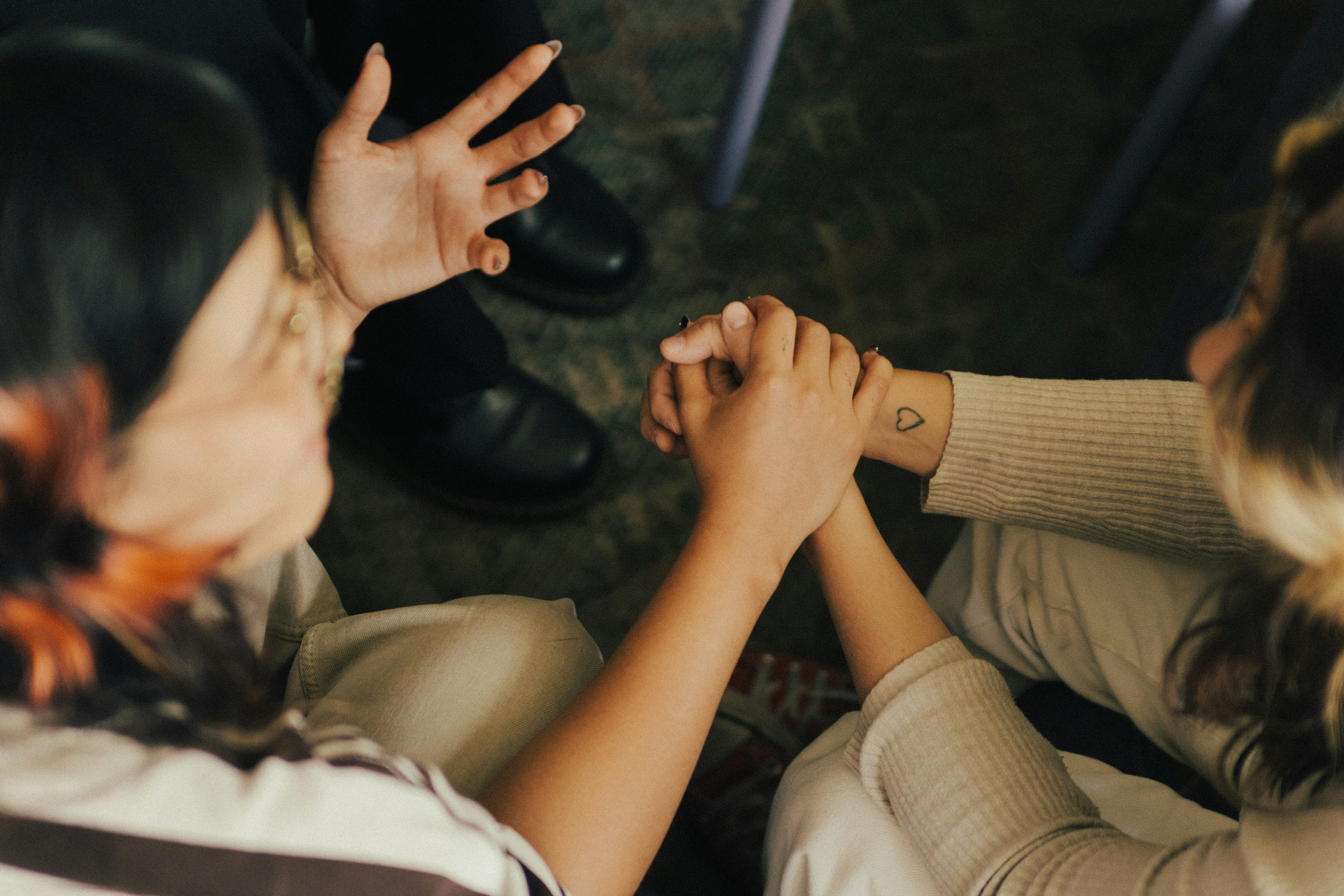 Girls holding hands talking and praying