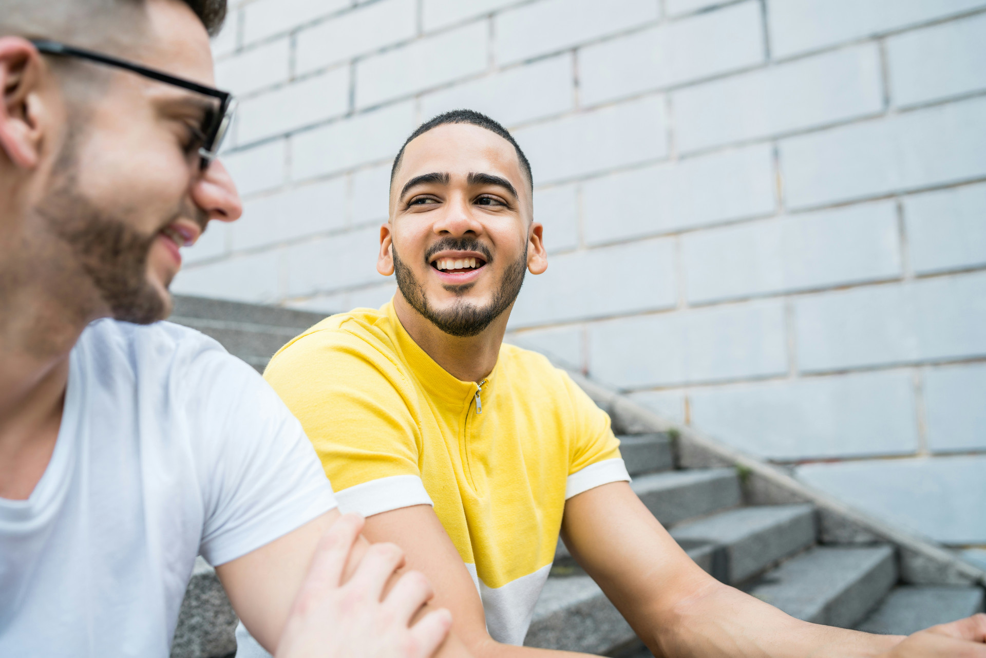 Two young men sitting on stairs talking and laughing