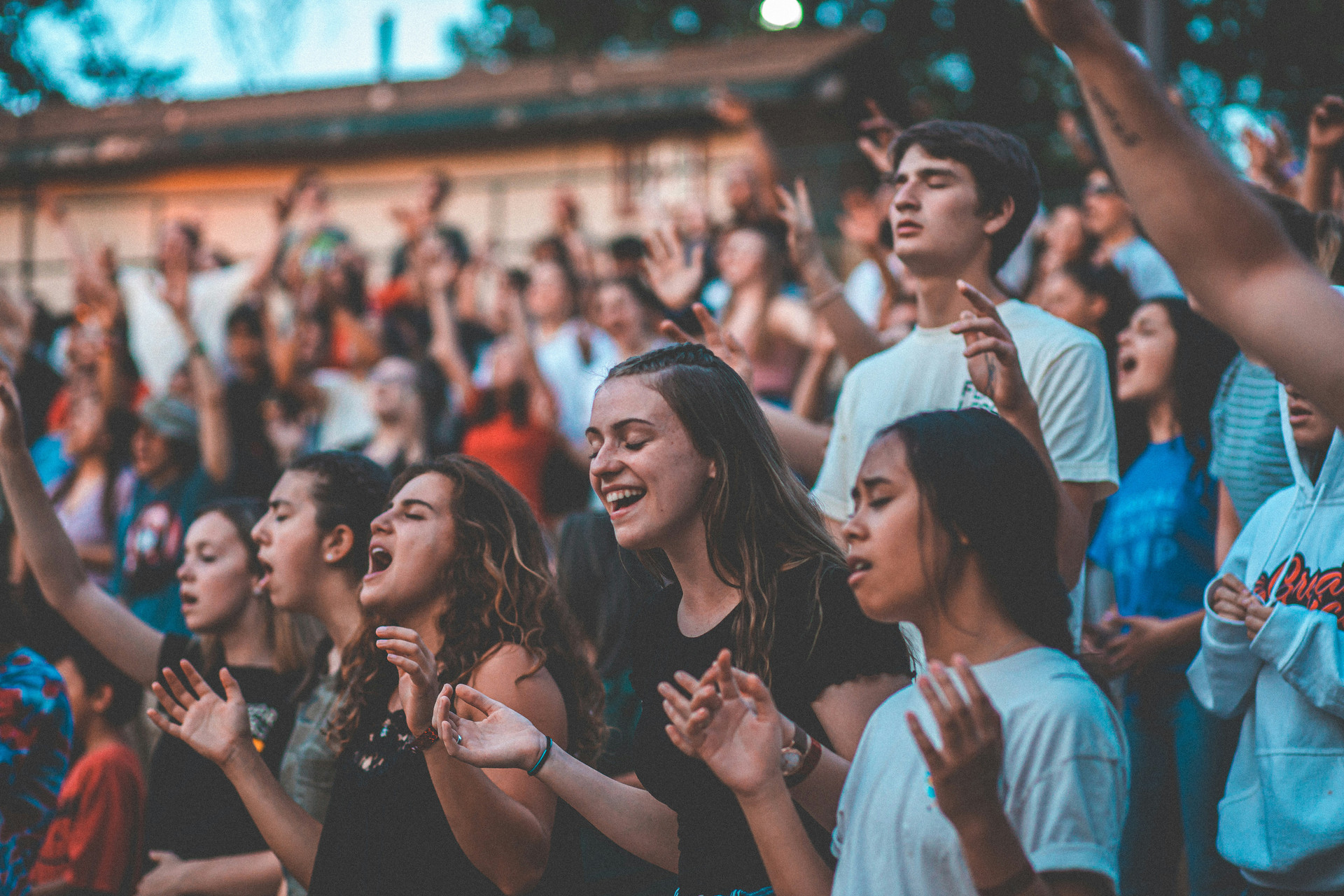 Students at outdoor amphitheater worshiping.