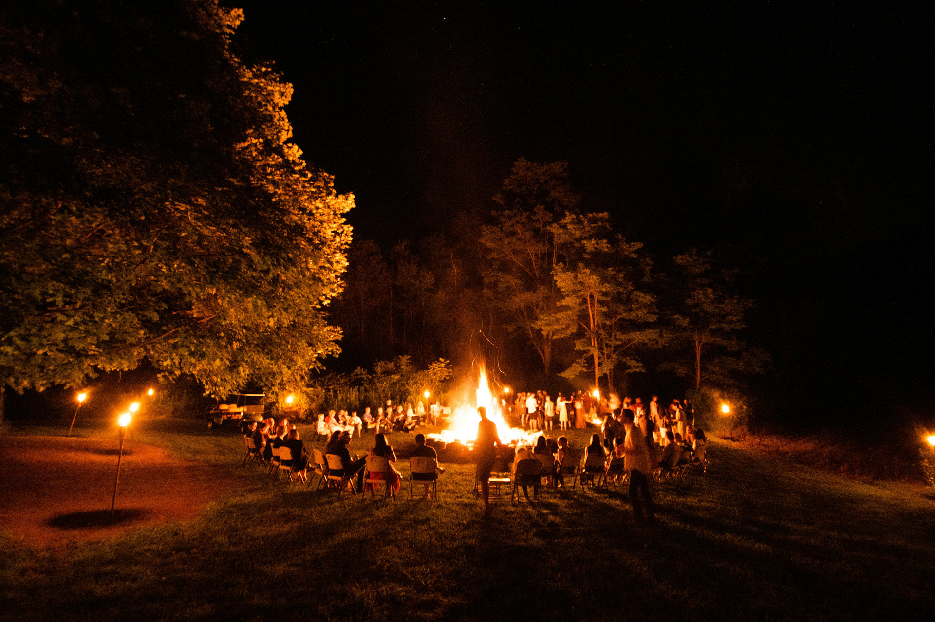 Students sitting around a fire at camp