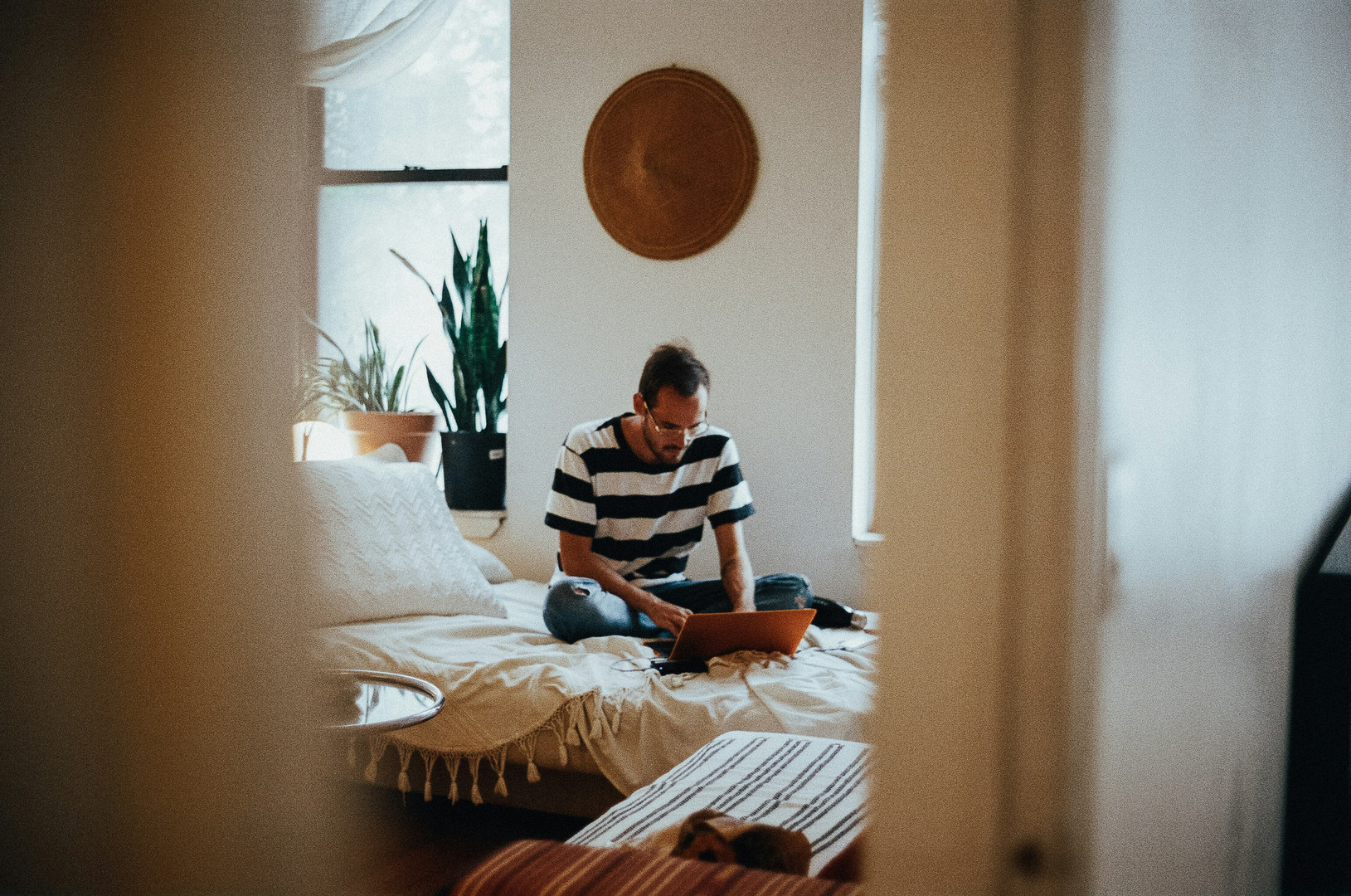 Young man sitting on his bed and reading