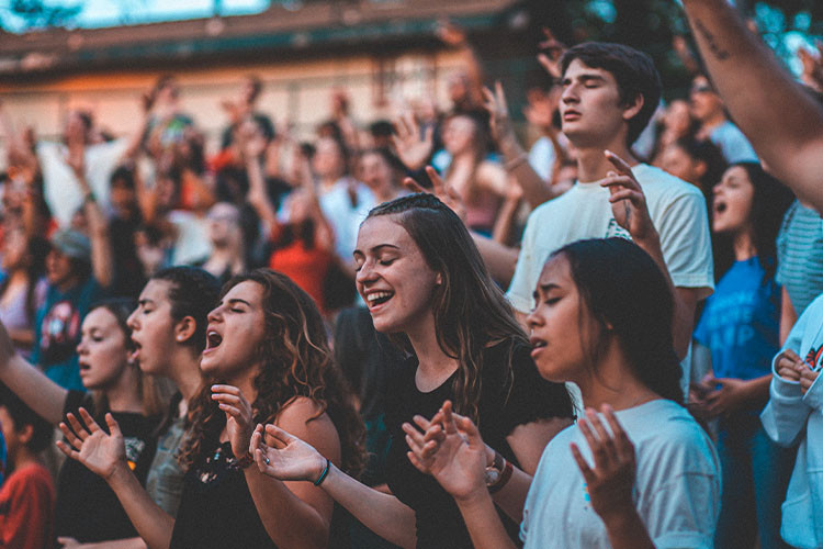 students worshipping in crowd